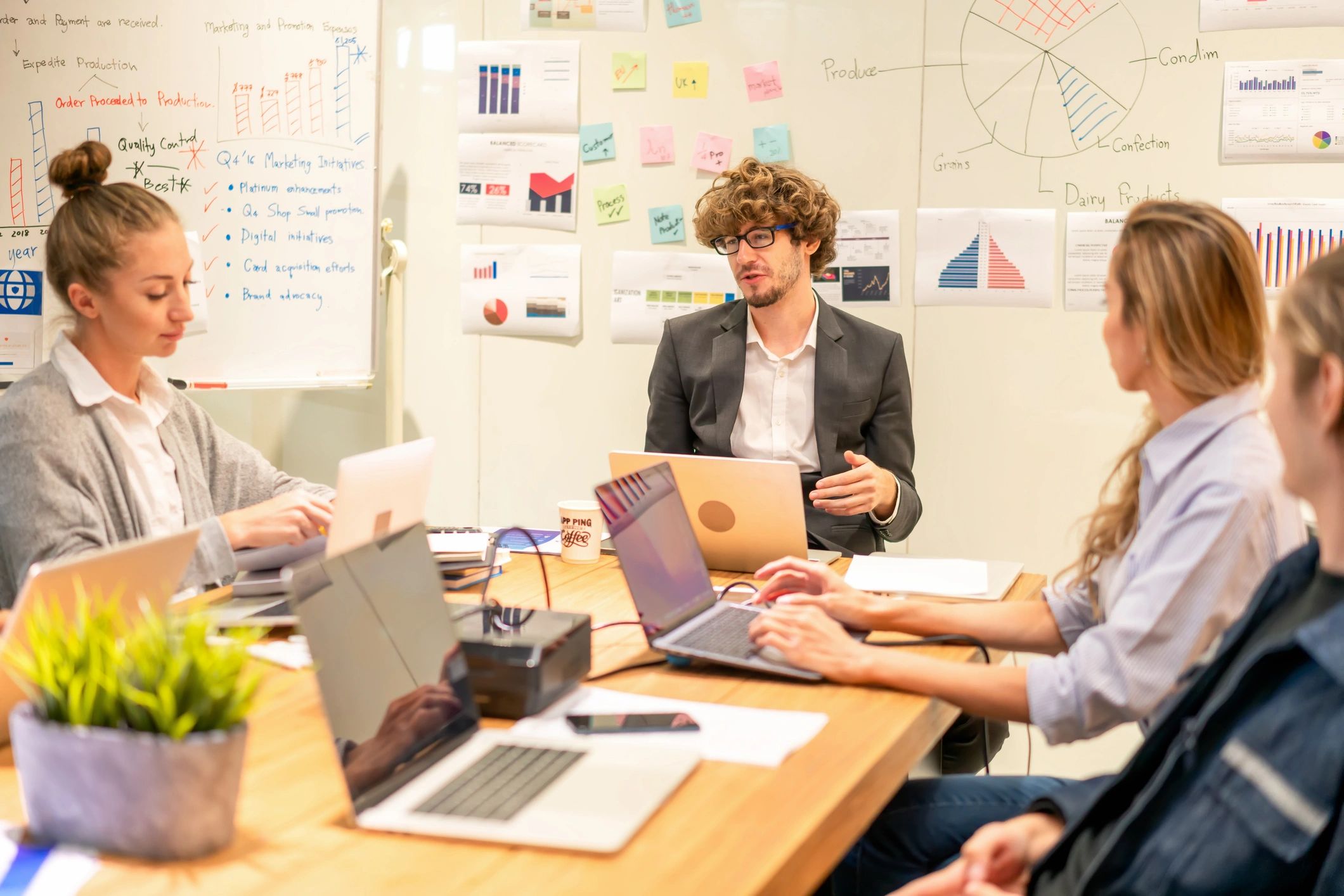 Small team collaborating around laptops in an office